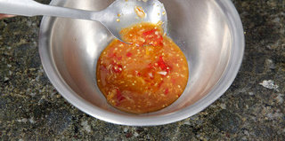 泰式海鲜沙拉,试尝酸辣汁的味道并做最后调味，随即倒入搅拌碗中