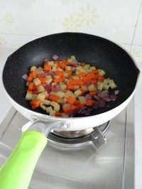 咖喱杂蔬,锅里倒油，放入土豆、胡萝卜和一半量的洋葱丁，炒至洋葱变软。