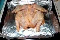 新奥尔良烤全鸡,将腌好的全鸡摆放入铺有锡纸的烤盘中