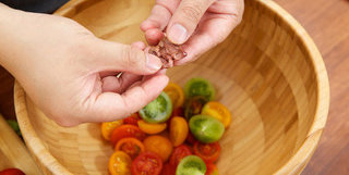 番茄沙拉,橄榄用手挤压后掰开，集中盛放在搅拌碗中