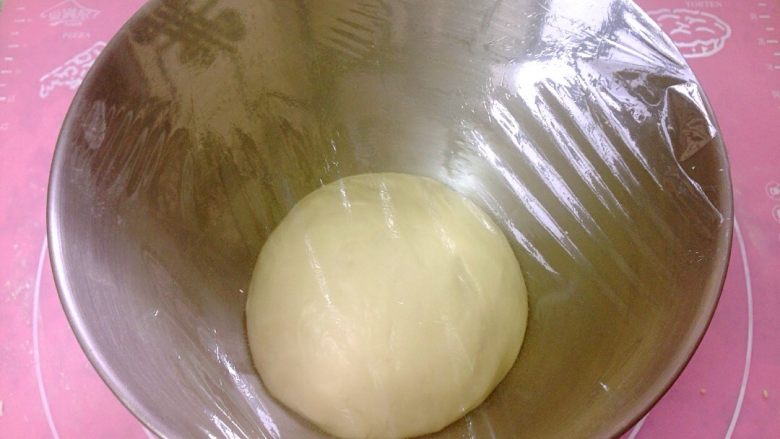 椰香奶酥辫子面包,揉好的面团滚圆，放入厨师机，盖上保鲜膜，进行一次发酵。