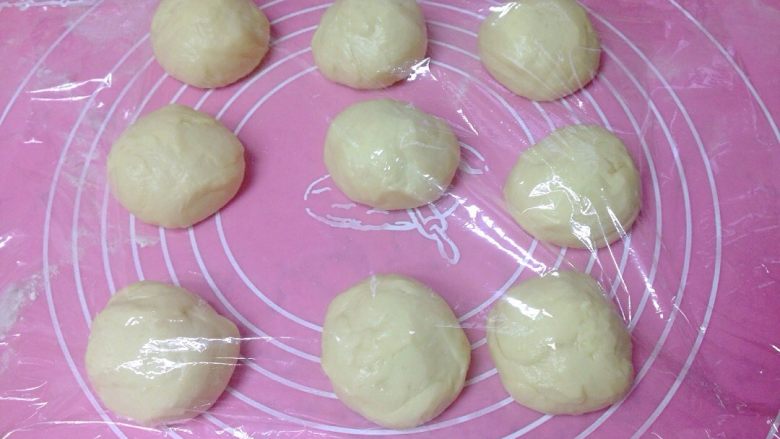 椰香奶酥辫子面包,发好的面团按压排气后，分成9等份，盖上保鲜膜松弛10分钟。