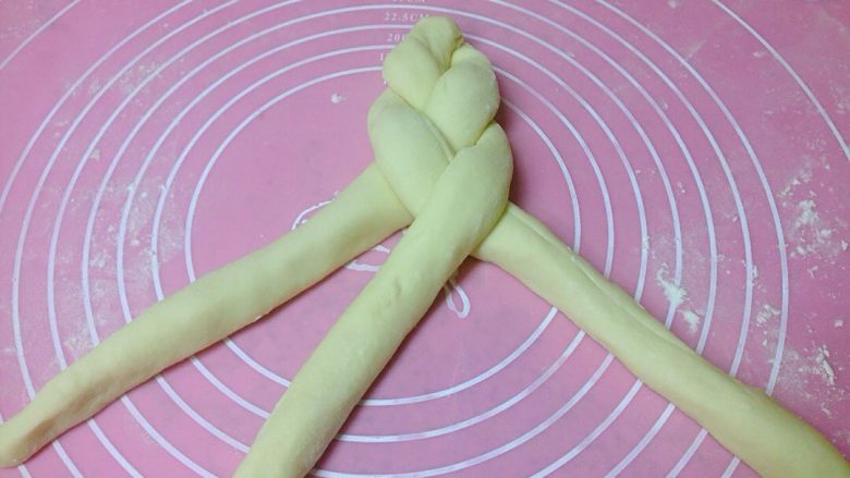 椰香奶酥辫子面包,把3根面卷编织成1根粗辫子。