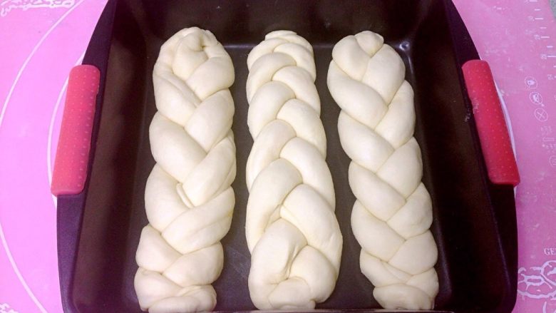 椰香奶酥辫子面包,编织好的3根粗辫子排入模具，进行二次发酵。