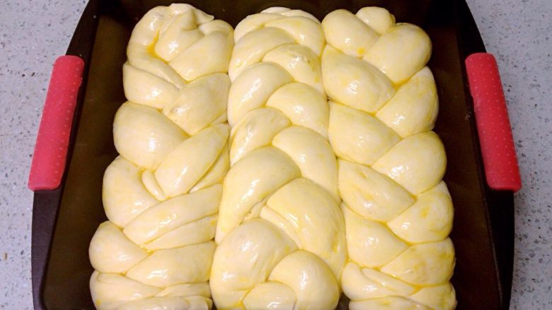 椰香奶酥辫子面包,烤箱预热180度。发酵好的面团表面刷一层全蛋液。