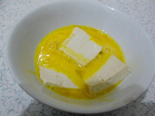 鱼香脆皮豆腐,蛋液中加入适量的淀粉搅拌均匀，将豆腐沾满蛋糊。