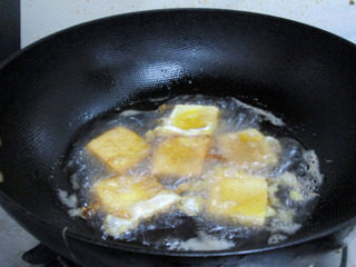 鱼香脆皮豆腐,下入6成热的油锅中煎炸至金黄。
