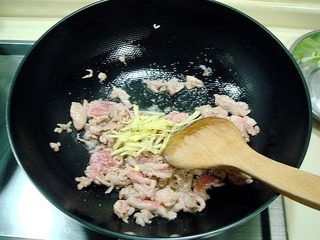 腐乳爆肉,炒勺上火烧热，注入适量油，下入肉片煸炒，肉片变色后放入姜丝翻炒。