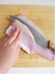水煮鱼,将片下的鱼肉鱼皮朝下，一手轻轻按着鱼肉