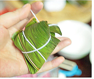 甜蜜红枣粽,反折成三角形状，用棉线捆绑结实