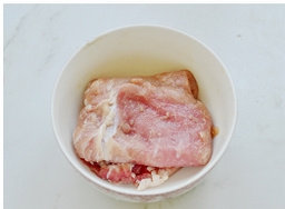 法式蓝带芝心猪排,把肉摊开放在案板上，并盖上一层保鲜膜。