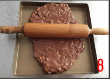 巧克力牛轧糖,将搅拌均匀的糖倒出来，放油布上，揉匀，倒在不沾烤盘上，用擀面杖擀薄
