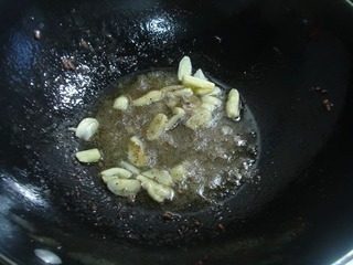 锅仔烧汁蘑菇,锅里放油，放入蒜片和黑胡椒炒香。