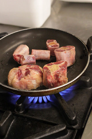 番茄红酒烩牛尾,平底锅烧热，倒入少许油，将调好味道的牛尾两面略煎上色，封住牛尾的肉汁