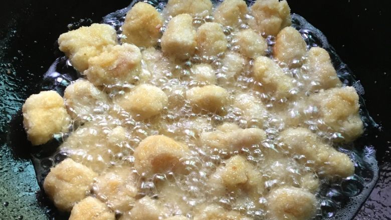 鸡米花,锅里倒油烧至六成熟，放入鸡肉块炸至金黄色