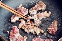 自制烤肉酱,平底锅或者烧烤的铁板烧热。
加少许的油，一片一片的放肉进去。不要来回翻动。看到肉片的边缘熟了才翻面。这样牛肉会有漂亮的上色。