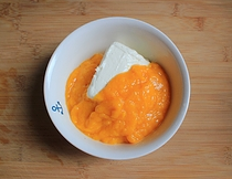 芒果酸奶冻芝士蛋糕,将芒果泥同奶油芝士隔水加热至奶油芝士变软，并用打蛋器将果泥同奶油芝士打至顺滑无颗粒。