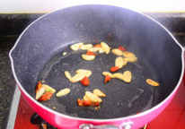 干锅菜花,炒锅中下油烧热，下姜蒜片煸香，再把干辣椒段放入。