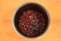 紫米红豆粥,泡好的红豆与洗干净的紫米放入压力锅内胆。