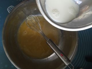 芒果千层蛋糕,蛋黄液里分三次加入牛奶，搅拌均匀。