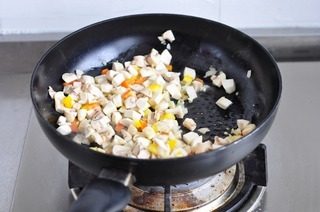 鸡肉蘑菇焗贝壳面,锅里放10克黄油，炒香洋葱和蒜末。放入蘑菇和三分之二的红黄椒，调入盐，胡椒粉。炒到蘑菇变软