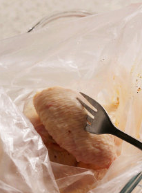 水牛城辣鸡翅,鸡翅洗净后擦干,用叉子或尖锐物将鸡翅穿刺数个洞,后入做法1调料袋中,方便腌渍入味