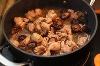 香菇滑鸡饭,加入香菇继续翻炒，加少许水把鸡块和香菇一起微炖5分钟。