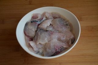 酸菜鱼,多冲洗几遍后沥干水分，加盐，料酒，蛋清，白胡椒粉和淀粉抓匀，腌制15分钟