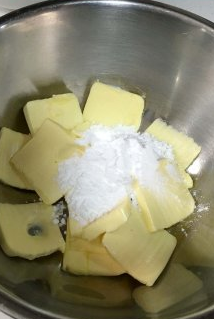 香蕉核桃磅蛋糕,将黄油放入盆软化，用打蛋器搅拌柔软，然后分次加入糖粉，打发黄油