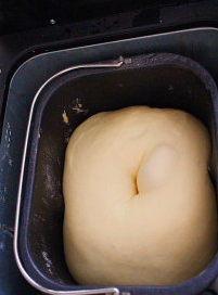 沙茶玉米手撕餐包 ,面团表面抹少许橄榄油,放回面包机中开始发酵动作,加盖拧干的湿布,发酵约45分钟后完成,叉洞不回缩