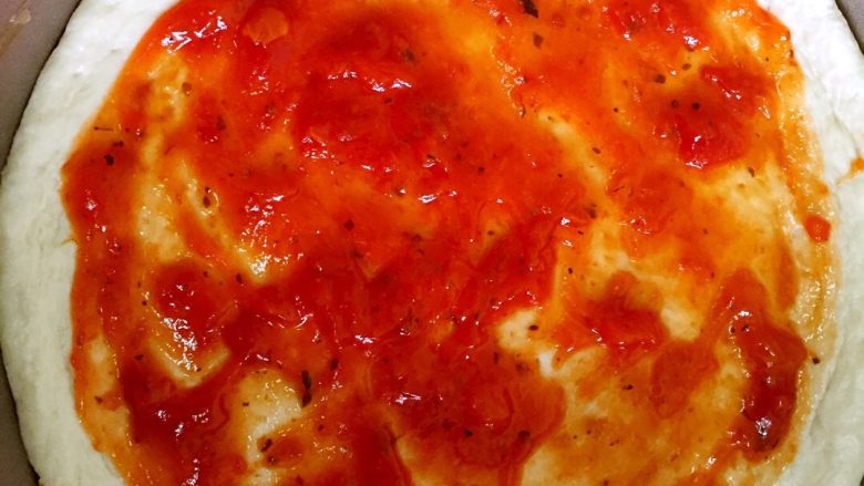 鲜虾蘑菇披萨,饼皮上刷<a style='color:red;display:inline-block;' href='/shicai/ 46963'>披萨酱</a>。