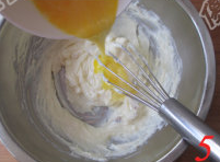椰香坚果乳酪条,加入细砂糖搅拌均匀，再分3次倒入打散的蛋液，分别搅拌均匀。