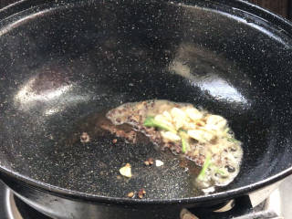 香烤鲫鱼,就着油锅放入花椒粒炸香，加入另一份葱姜蒜炒香