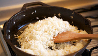 海南鸡饭,将滤干的米饭放入一起翻炒，后用煮鸡的汤汁上盖煮饭