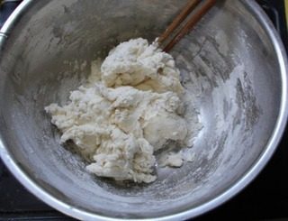 猪肉豆角锅贴,饺子粉中加入适量水，用筷子慢慢搅拌成棉絮