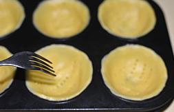 椰香芒果挞,冷藏好的面团取出后平均分成6份，在模具中按压出挞皮，用叉子底部叉出小孔。