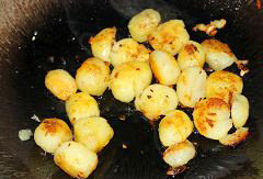 孜然椒盐小土豆,锅里热油，放入一半的蒜蓉，爆香，再放入小土豆，小火煎至略显金黄，表皮有点脆，土豆装起备用