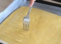 法式杏仁焦糖脆饼,用叉子在整张面片上均匀地戳出小孔。
然后送进烤箱，170°，烤12分钟。