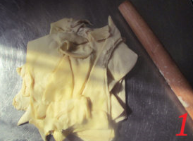 酥皮香肠卷,桌上撒少许面粉防粘，把多余的派皮叠放在一起。