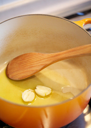 烩牛尾,预热橄榄油，煎香蒜瓣至焦糖色。烤箱预热180度