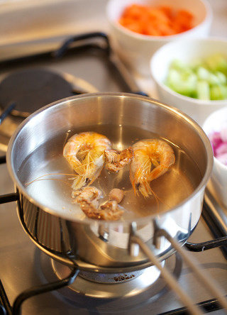 烩牛尾,另起锅将干货沸煮后过滤成高汤备用，同时用高汤煮一部分蔬菜备用，为保持装盘色泽