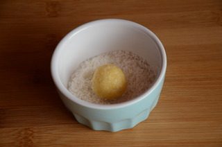 黄金椰丝球,取一小块面团，搓成小球，在椰丝碗里滚一圈，表面均匀沾上椰丝