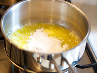 奶油白酱管面,放入面粉并缓慢、充分搅拌。略翻炒一会儿，至面粉没有干粉快，混合物呈金黄色小团。这一步制成的黄油面团结块称为roux，在制作浓汤的时候可当作增稠剂，可令浓汤拥有更加豪华的口感