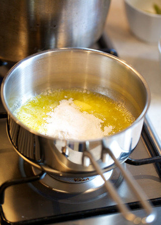 奶油白酱管面,放入面粉并缓慢、充分搅拌。略翻炒一会儿，至面粉没有干粉快，混合物呈金黄色小团。这一步制成的黄油面团结块称为roux，在制作浓汤的时候可当作增稠剂，可令浓汤拥有更加豪华的口感