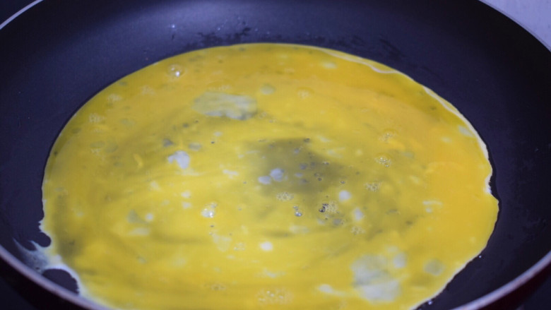 秋葵煎蛋,平底不粘锅刷一层薄薄的食用油后开小火，倒入1/3的蛋液轻轻转动锅子，使蛋液铺满锅底