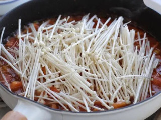 金针菇番茄汤,再倒入二百毫升的清水，把金针菇铺到上面大火煮沸，再改小火煮至金针菇变软、汤汁呈黏稠状态。