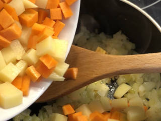 日式鸡排咖喱饭🍛,炒软后，加入土豆和胡萝卜煸炒5分钟。煸炒的目的是为了炒出土豆和胡萝卜的香味。