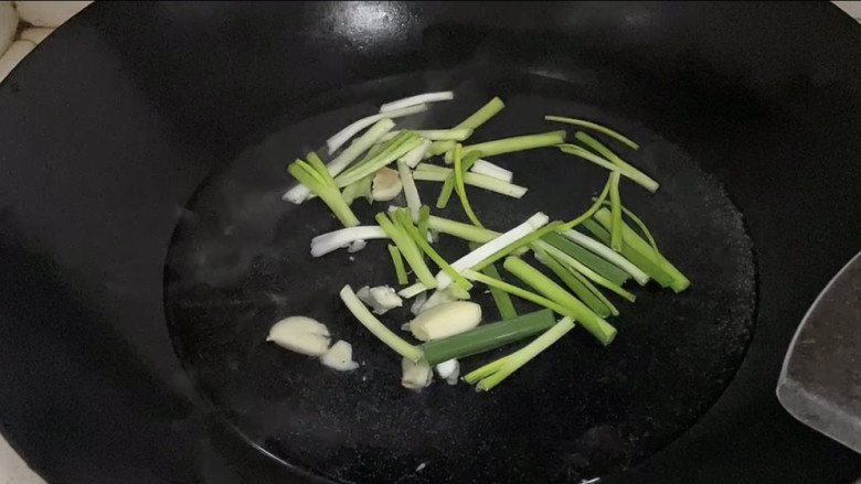 酸菜海鲜锅,锅中倒入适量清水煮沸后加入葱，蒜