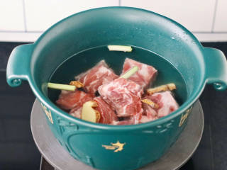 砂锅脊骨煲,砂锅里倒入适量的清水，放入脊骨和葱姜，倒入料酒。