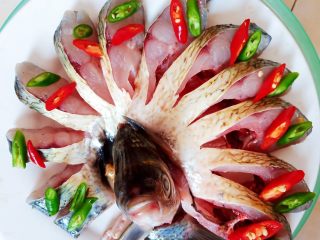 油泼鱼,腌好的鳊鱼切断头尾，中间部分每隔一厘米左右切一刀，注意不要切断。切好的鳊鱼摆盘，